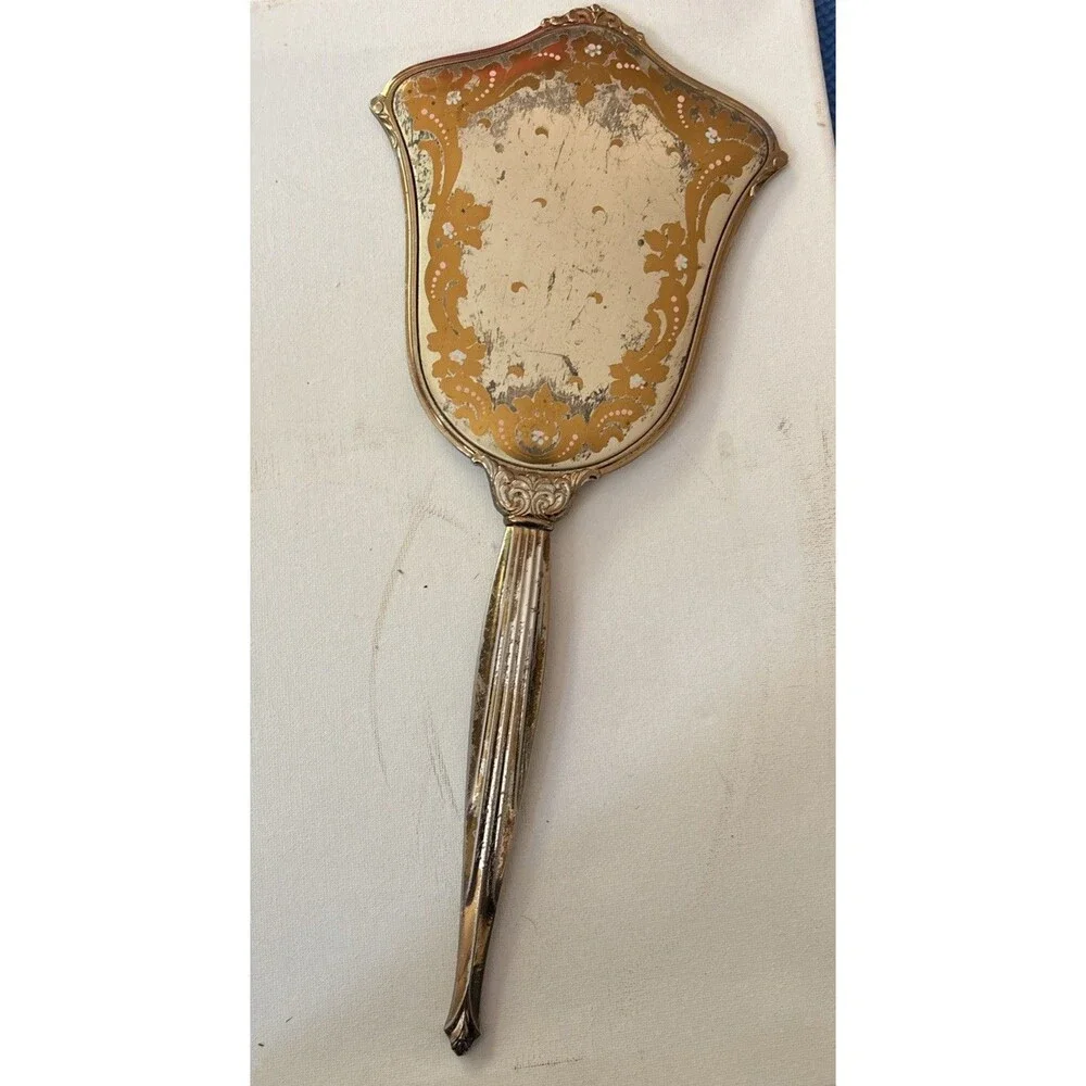 Vintage or antique gold-tone handheld vanity mirror.